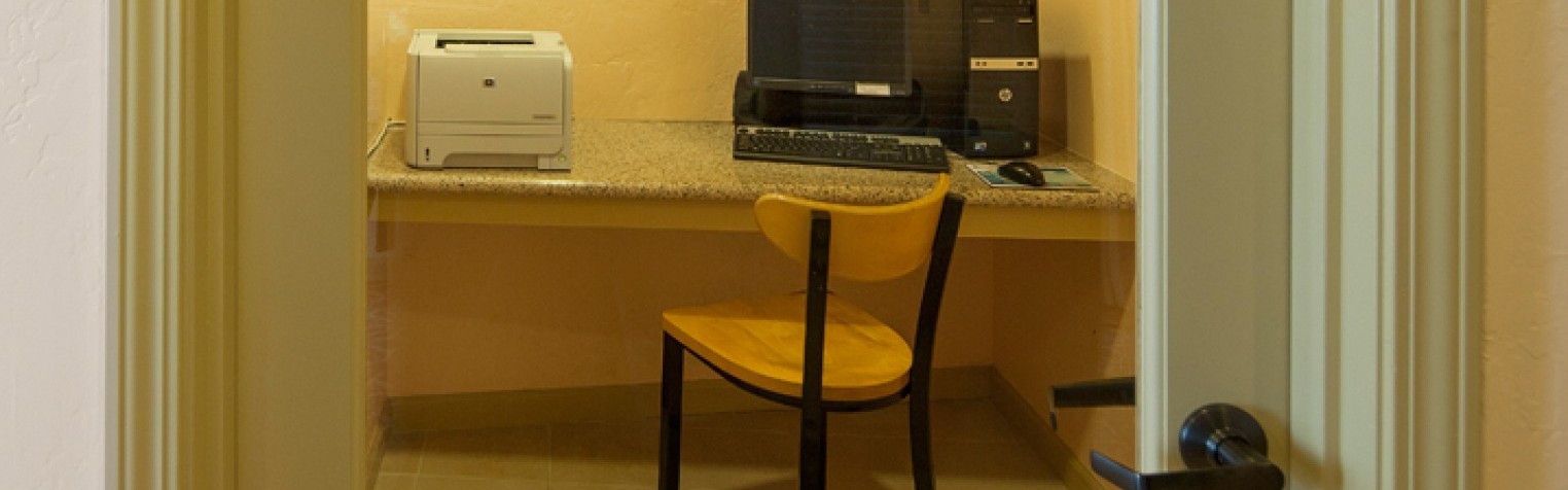 Sand Piper Lodge business center complete with a computer, monitor, and printer available for use by guests.