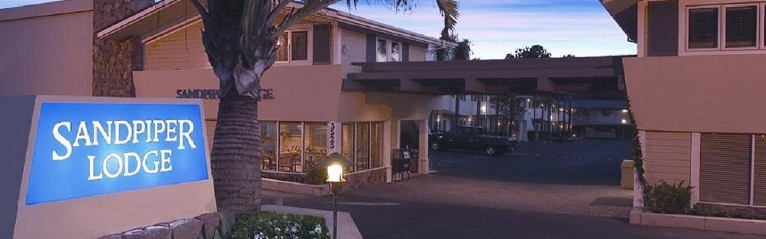 The front view of Sandpiper Lodge, including their parking lot.