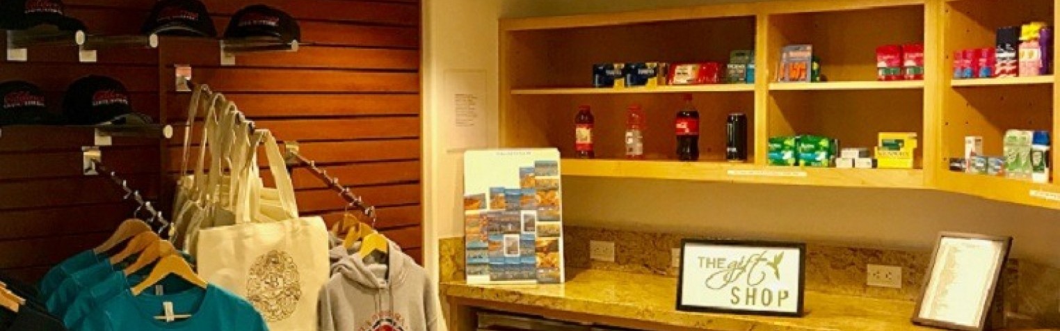 Sandpiper Lodge gift shop, displaying t-shirts, hats, sweatshirts, drinks, and medication.